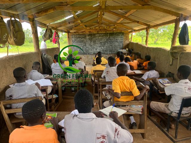Pupils working in a classroom with a wooden roof and a blackboard