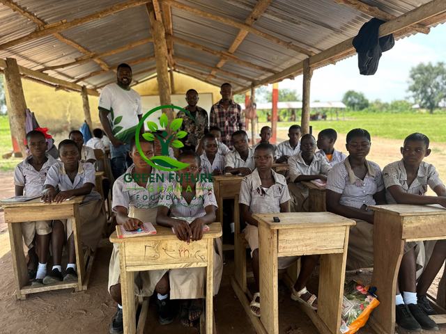 Pupils in school uniform at wooden desks in an open-sided classroom
