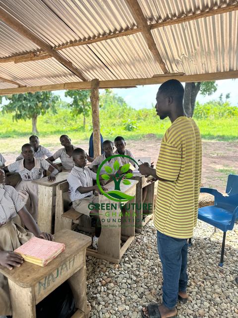 A teacher standing in front of pupils in an open-air classroom