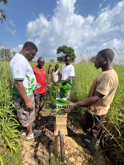 Foundation team members and local men standing together in a field of tall grass